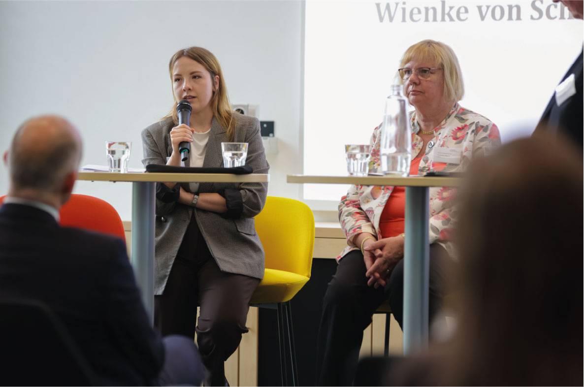 Podiumsdiskussion auf dem 6. Außenwirtschaftsseminar der Agrar- und Ernährungswirtschaft in Bonn. Eine Referentin spricht mit Mikrofon über aktuelle Entwicklungen und Herausforderungen auf internationalen Agrarmärkten. Neben ihr verfolgt eine weitere Expertin die Diskussion. Die Veranstaltung bringt Vertreter aus Wirtschaft, Politik und Verbänden zusammen, um über Exportchancen und Rahmenbedingungen für die deutsche Agrar- und Ernährungswirtschaft zu diskutieren.