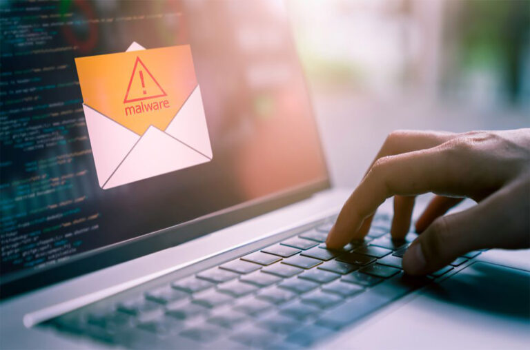 Eine Hand auf dem Keyboard eines Laptops, die gerade eine Malware-Warnung öffnet