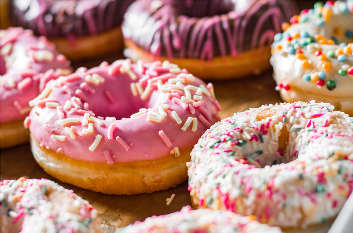 Donuts mit Zuckerguss, Schokoladenglasur und bunten Streuseln.