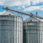 Moderne landwirtschaftliche Getreidespeicher aus Stahl. Landwirtschaftliche Silos zur Lagerung der Getreideernte auf einem landwirtschaftlichen Produktionsbetrieb.