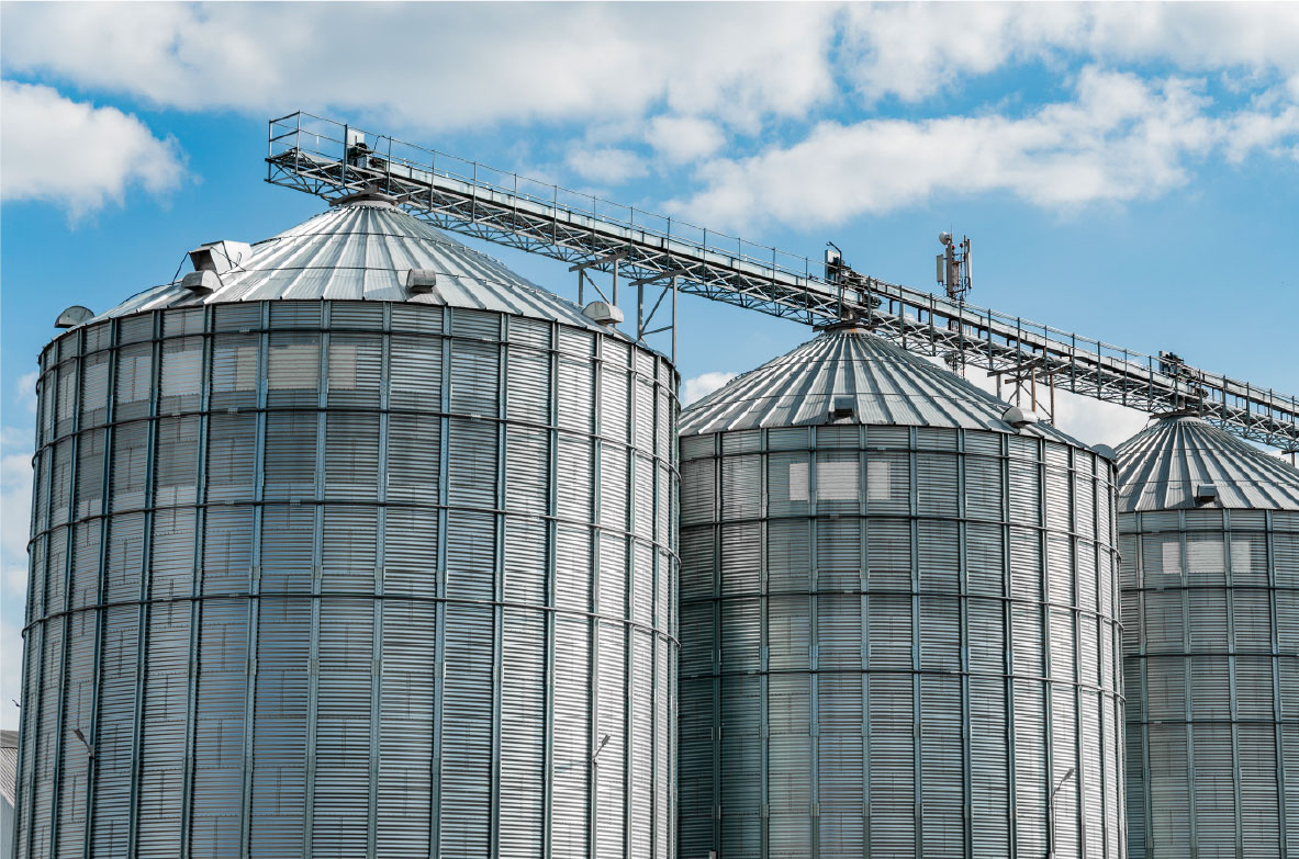 Moderne landwirtschaftliche Getreidespeicher aus Stahl. Landwirtschaftliche Silos zur Lagerung der Getreideernte auf einem landwirtschaftlichen Produktionsbetrieb.