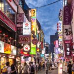 Belebte Einkaufsstraße im Myeong-dong-Viertel von Seoul bei Nacht mit Leuchtreklamen – Symbol für den boomenden Lebensmittelhandel in Südkorea