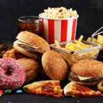 Vielfalt an Fast Food: Burger, Pommes, Pizza, Donuts, Süßigkeiten und Softdrink