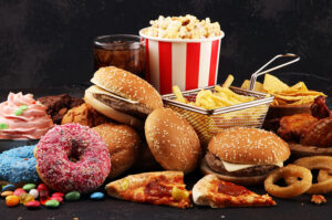Vielfalt an Fast Food: Burger, Pommes, Pizza, Donuts, Süßigkeiten und Softdrink