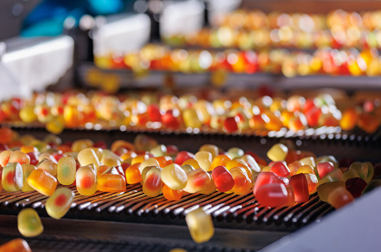 Bunte Fruchtgummis auf einem modernen Fließband in einer Süßwarenfabrik