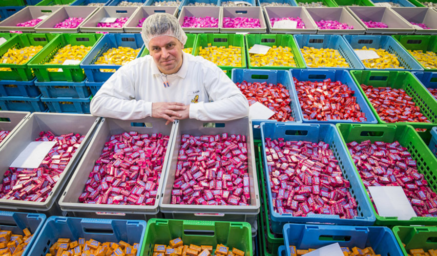 Bunte Kisten voller verpackter Maoam-Kaubonbons in einer Haribo-Fabrik
