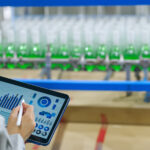 Mitarbeiter überwacht Getränkeproduktion mit Tablet und Datenanalyse