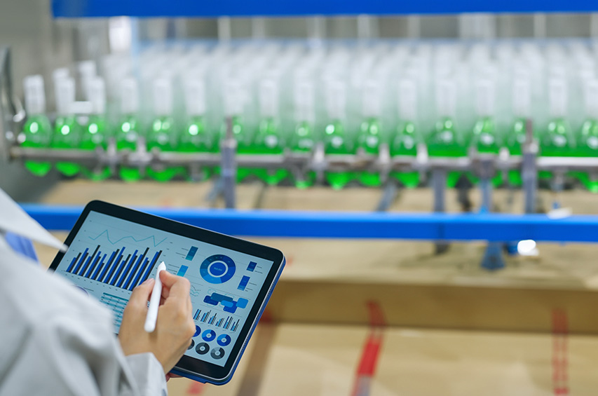 Mitarbeiter überwacht Getränkeproduktion mit Tablet und Datenanalyse