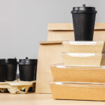Einweg-To-go-Verpackungen und Coffee-to-go-Becher aus Kunststoff und Karton auf einem Tisch