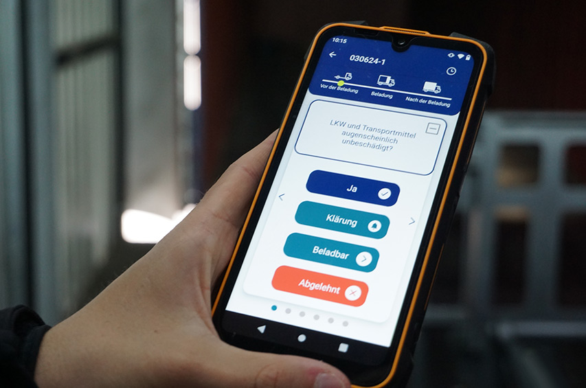 Mitarbeiter nutzt Smartphone mit digitaler Checkliste in der Logistik