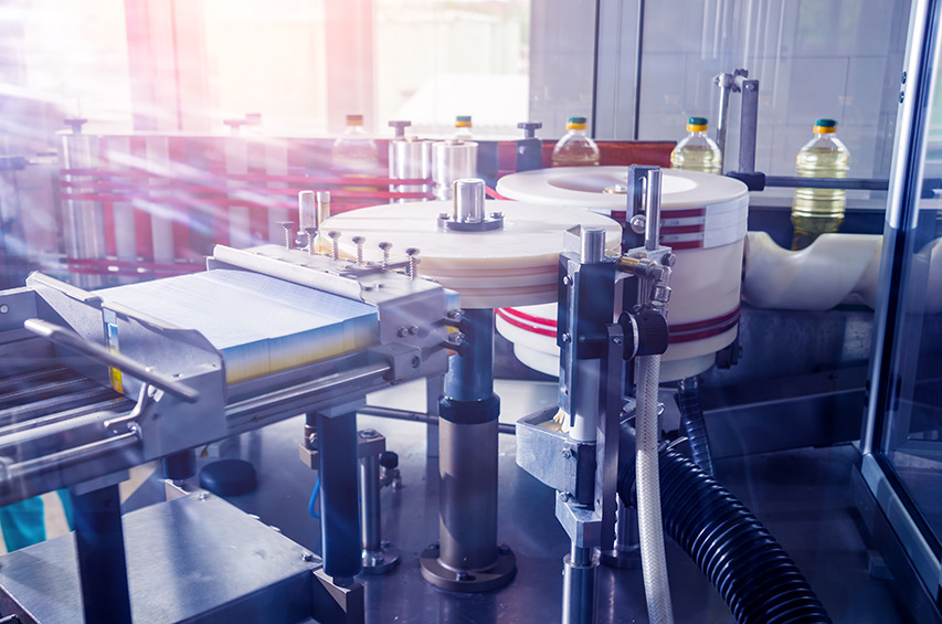 Kunststoffflaschen durchlaufen eine automatisierte Abfüll- und Etikettieranlage.