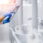 Mitarbeiterin in der Lebensmittelproduktion prüft Prozessdaten auf einem Tablet.