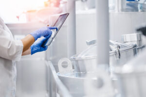 Mitarbeiterin in der Lebensmittelproduktion prüft Prozessdaten auf einem Tablet.