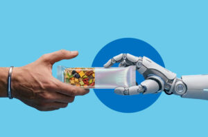 Eine menschliche Hand und eine Roboterhand halten gemeinsam einen Müsliriegel in transparenter Verpackung.