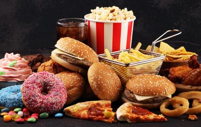 Vielfalt an Fast Food: Burger, Pommes, Pizza, Donuts, Süßigkeiten und Softdrink