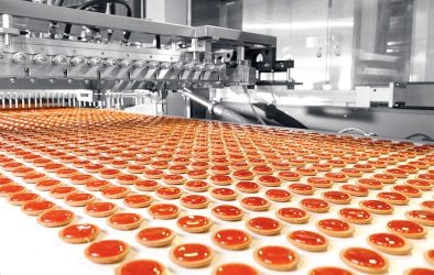 Automatisierte Keksproduktion mit roter Füllung auf einem Fließband in einer modernen Lebensmittelproduktion