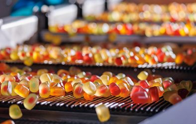 Bunte Fruchtgummis auf einem modernen Fließband in einer Süßwarenfabrik