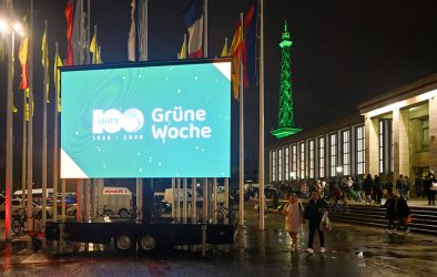 Große LED-Leinwand mit dem Logo zum 100jährigen Jubiläum der Grünen Woche vor dem Messegelände Berlin bei Nacht.