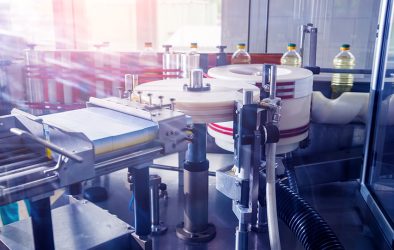 Kunststoffflaschen durchlaufen eine automatisierte Abfüll- und Etikettieranlage.
