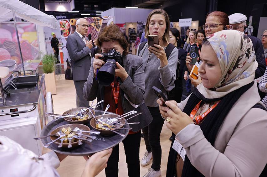 Journalistinnen und Journalisten fotografieren die Wurst aus Pilzmyzel auf der Anuga