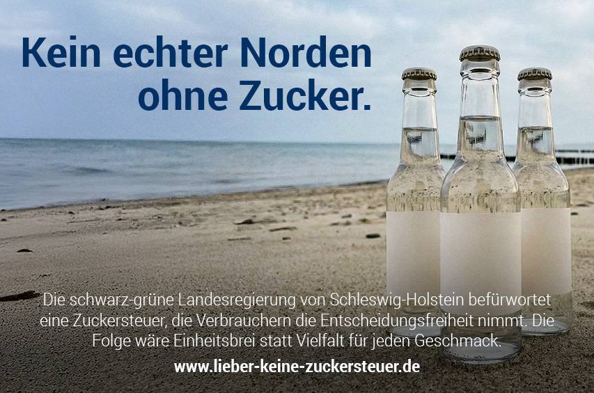 Vier transparente Getränkeflaschen ohne Etikett stehen am Strand, im Hintergrund Meer und Himmel.